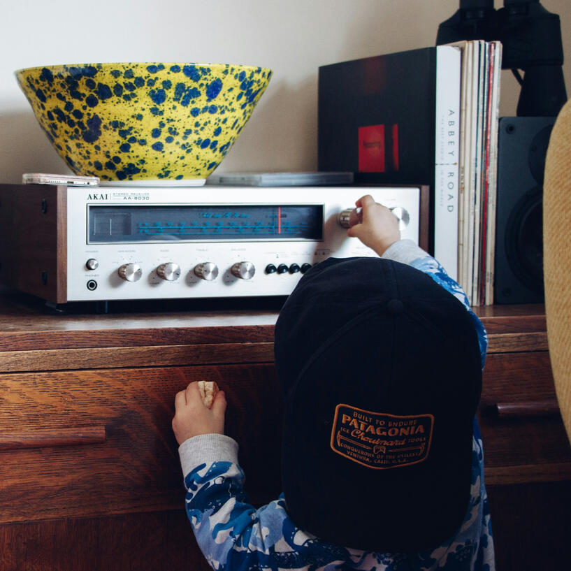 life-story-studio-child-tuning-stereo.jpg A small child turning up the volume of a stereo.